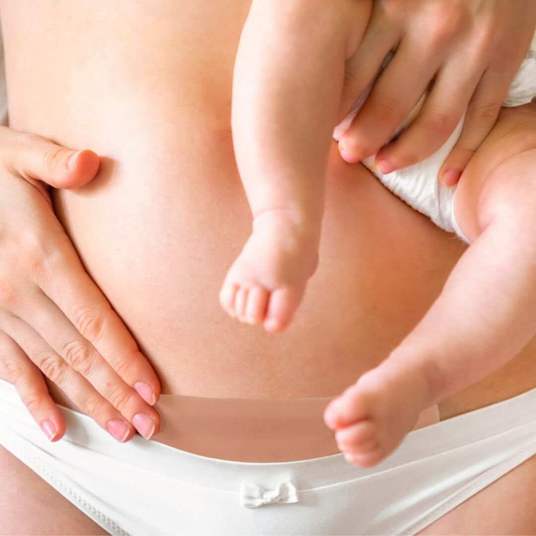 Mãe segurando bebê perto da barriga